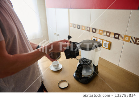 Morning Coffee: Person Pouring From Drip Coffee Maker Into Small Cup In Kitchen Morning Coffee: Person Pouring From Drip Coffee Maker Into Small Cup In Kitchen 132785834