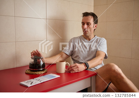 Casual Morning Coffee Break With Man At Red Kitchen Counter 132785844