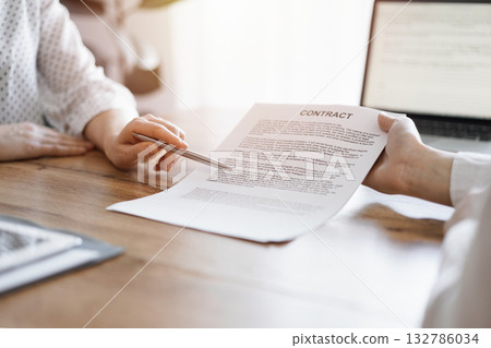 Businesswoman lawyer pointing into contract special points admitting something for colleague or client at the wooden desk in office. Business people teamwork and partnership, meeting concept 132786034