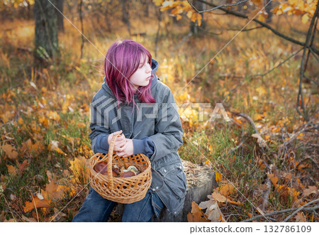 Young girl holding mushroom basket in autumn forest 132786109