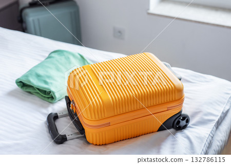 Travel suitcase on hotel bed preparing for journey Travel suitcase on hotel bed preparing for journey 132786115
