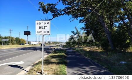 An American highway with a sign indicating movement and a right turn, an empty highway during the day with information signs and an electronic board, road markings and signs indicating the direction An American highway with a sign indicating movement and a right turn, an empty highway during the day with information signs and an electronic board, road markings and signs indicating the direction 132786698