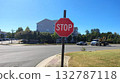 Chantilly, Virginia, USA - 10.25.2025: A red metal road sign with eight corners demanding a stop is located next to the roadway and covers a residential building and trees on a clear sunny day 132787118