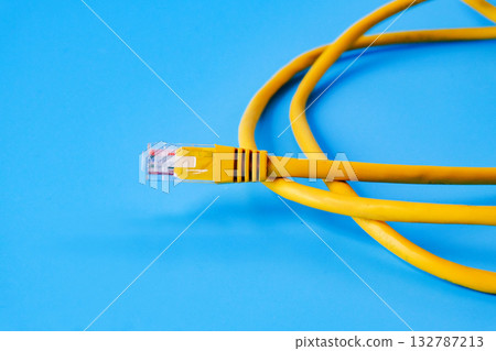Yellow RJ45 Ethernet cable on color background. Yellow RJ45 Ethernet cable on color background. 132787213