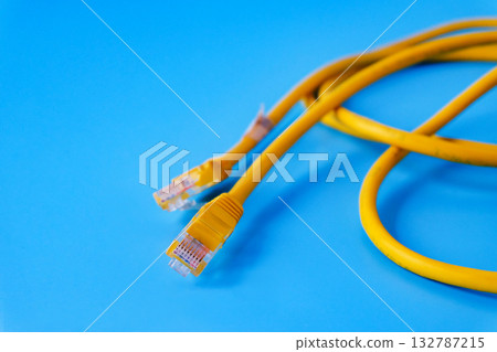 Yellow RJ45 Ethernet cable on color background. 132787215