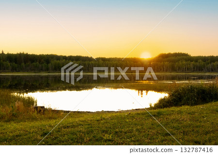 Beautiful scene at the lake in the woods, golden sunset light. Beautiful scene at the lake in the woods, golden sunset light. 132787416