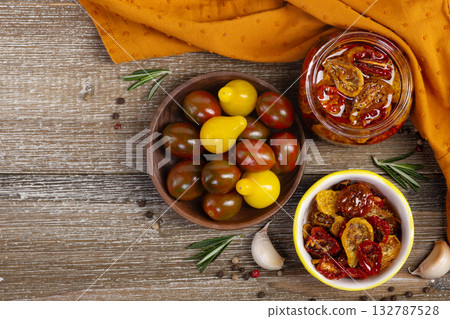 Flatlay of dried cherry tomatoes in a jar and plate with ingredients. Flatlay of dried cherry tomatoes in a jar and plate with ingredients. 132787528