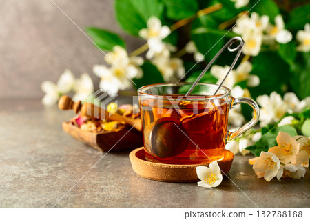 Cup of jasmine tea and fresh jasmine flowers on a stone table. 132788188