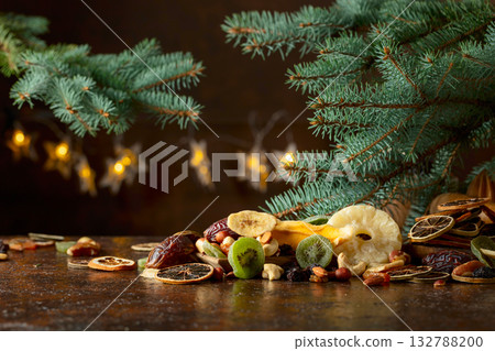 Dried tropical fruits with various nuts and raisins on a old brown table. 132788200