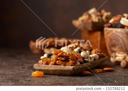 Mix of nuts and raisins on a brown rustic background. 132788212