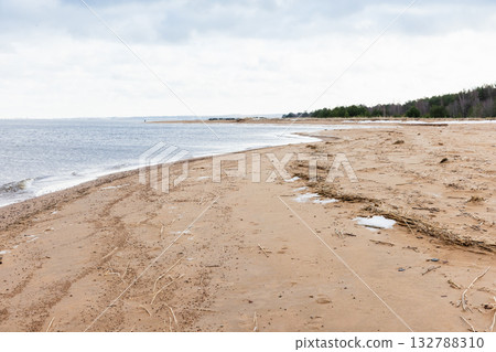 A tranquil coastal scene features a long sandy beach in winter A tranquil coastal scene features a long sandy beach in winter 132788310