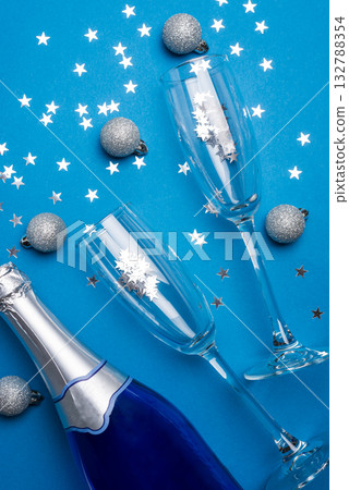 Champagne Bottle and Flutes with Silver Ornaments for New Year Celebration on Blue Background 132788354