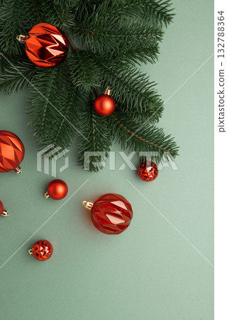 Red Christmas Ornaments Hanging on Pine Branches over Muted Green Background 132788364