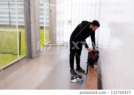 Young caucasian male in sports center with backpack and sports shoes Young caucasian male in sports center with backpack and sports shoes 132788427