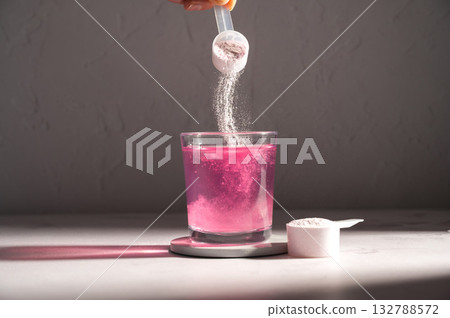 Pouring food supplement powder in glass of water. Collagen, protein powder, vitamins. Pouring food supplement powder in glass of water. Collagen, protein powder, vitamins. 132788572