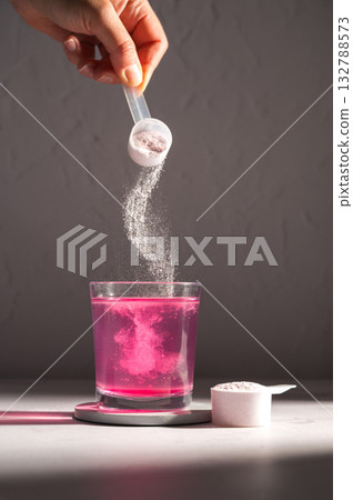Pouring food supplement powder in glass of water. Collagen, protein powder, vitamins. Pouring food supplement powder in glass of water. Collagen, protein powder, vitamins. 132788573