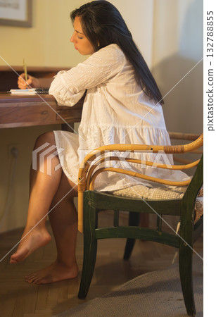 Young woman writing thoughts on notebook at desk. Romantic portrait Young woman writing thoughts on notebook at desk. Romantic portrait 132788855