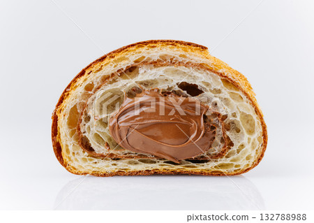 Close-up of croissant cross-section filled with creamy chocolate hazelnut spread 132788988