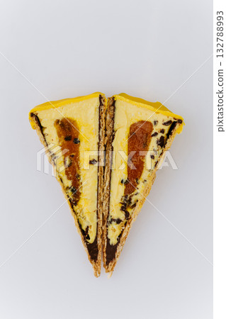 Sliced yellow ice cream cone with caramel and chocolate filling on white background Sliced yellow ice cream cone with caramel and chocolate filling on white background 132788993