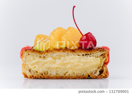 Close-up of a fruit Danish pastry with kiwi, orange slices, and cherry on pink icing Close-up of a fruit Danish pastry with kiwi, orange slices, and cherry on pink icing 132789001