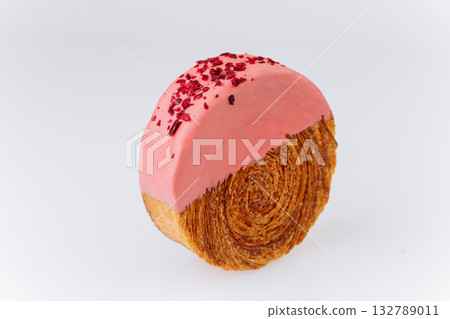 Pink glazed croissant roll with dried raspberry topping on white background Pink glazed croissant roll with dried raspberry topping on white background 132789011