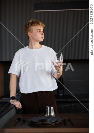 Individual gazing thoughtfully through window with soft lighting Individual gazing thoughtfully through window with soft lighting 132789140