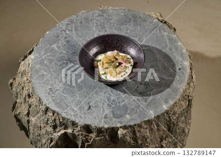 An Artistic Plated Dish Presented on a Unique Stone Surface for an Elevated Dining Experience An Artistic Plated Dish Presented on a Unique Stone Surface for an Elevated Dining Experience 132789147