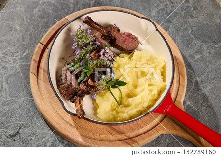 Indulge in Grilled Lamb Chops served alongside Creamy Mashed Potatoes garnished with Fresh Herbs Indulge in Grilled Lamb Chops served alongside Creamy Mashed Potatoes garnished with Fresh Herbs 132789160