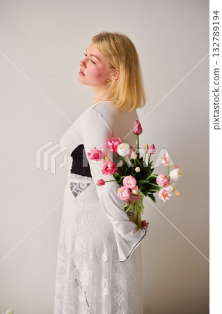 Dreamy studio shot of blonde woman holding flowers with vintage 132789194