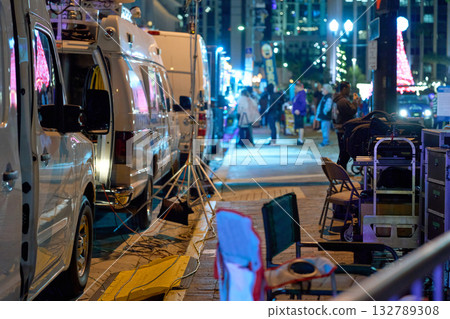 News vans, tripods, and gear fill a city street during a nighttime event. Journalists and crews set up equipment for live broadcast and editorial coverage. News vans, tripods, and gear fill a city street during a nighttime event. Journalists and crews set up equipment for live broadcast and editorial coverage. 132789308