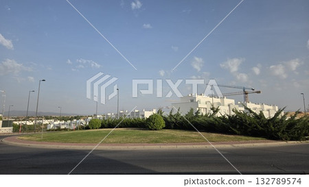 Modern residential construction site with crane and houses under clear sky Modern residential construction site with crane and houses under clear sky 132789574