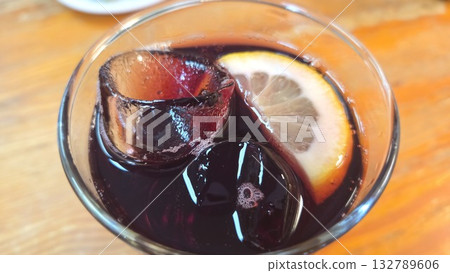 Refreshing beverage with lemon and ice cubes on a sunny day. Spanish drink tinto de verano. Close-up Refreshing beverage with lemon and ice cubes on a sunny day. Spanish drink tinto de verano. Close-up 132789606