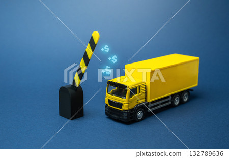 An open barrier lets a truck through. Tolls and toll roads. Payment of customs duty. Transportation infrastructure, cargo delivery, customs clearance. Concept of logistics, trade, and border control. An open barrier lets a truck through. Tolls and toll roads. Payment of customs duty. Transportation infrastructure, cargo delivery, customs clearance. Concept of logistics, trade, and border control. 132789636