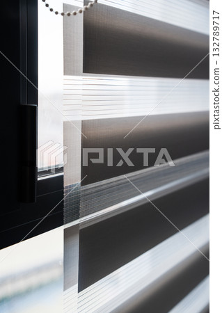 Macro view of zebra blind fabric layers with sunlight shining through 132789717