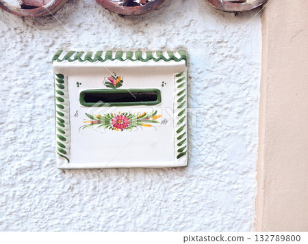 Traditional ceramic mailbox on white wall in Tenerife. Spanish craftsmanship, folk art, and Mediterranean heritage reflecting island identity. 132789800