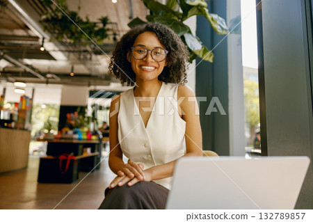 female entrepreneur using laptop, studio shot of smiling professional woman at workspace desk 132789857