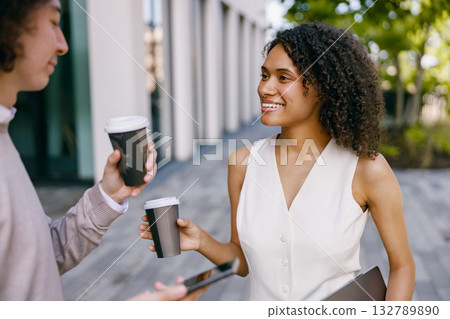 urban colleagues chatting, individuals in modern attire share relaxed moment outside of their 132789890