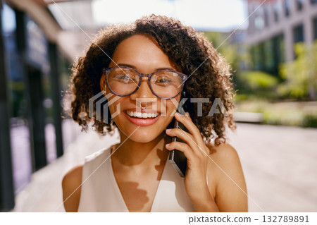 outdoor shot of confident woman on call, vibrant city scene captured with friendly professional 132789891