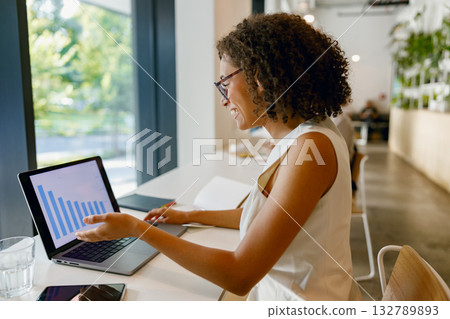 female professional engages with visual data representation during insightful meeting in vibrant 132789893