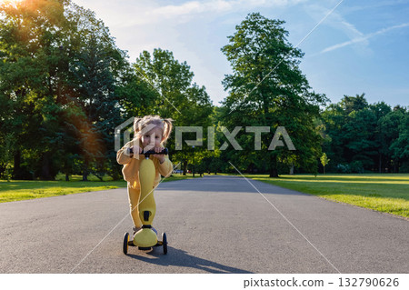 Child riding. Scooter toddler park play. Summer road motion casual sport. 132790626