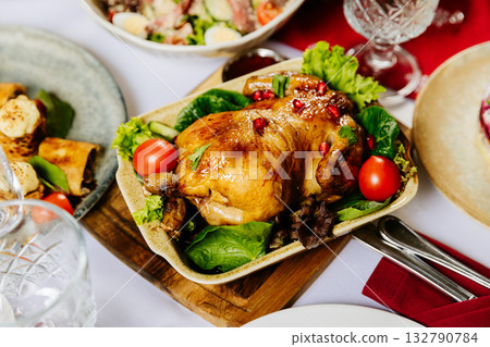 Roasted chicken with pomegranate and vegetables served on festive holiday table 132790784