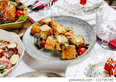 Golden crepes rolls with mushroom filling and cheese served on a festive table setting 132790790
