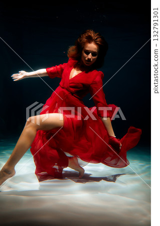 Contemplative woman in flowing dress surrounded by calm waters 132791301