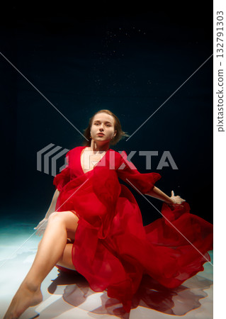 Underwater Caucasian model exudes confidence in luxurious red 132791303