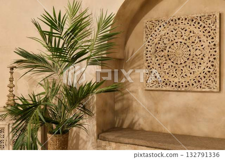 Bohemian Mediterranean interior with carved wall art, potted palm and textured stucco niche 132791336