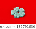 Blue heart pills on a red background are arranged in the shape of a flower. 132791630