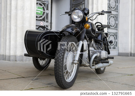 An old vintage black motorcycle with a sidecar stands at an open exhibition An old vintage black motorcycle with a sidecar stands at an open exhibition 132791665