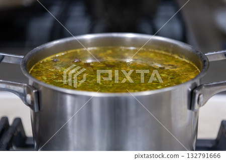 Fresh vegetable soup is cooked in a saucepan Fresh vegetable soup is cooked in a saucepan 132791666