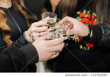 Group of people clinking glasses with white wine or champagne at festive celebration 132792097