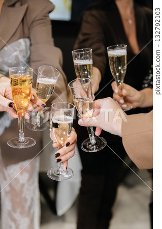 Group of people toasting with champagne glasses at festive celebration or corporate event 132792103